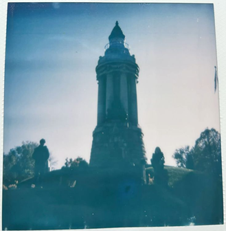 Lighthouse tower silhouetted against a blue sky